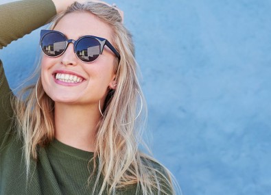 Mulher com óculos escuros sorrindo